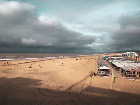 Weer den haag boven Scheveningen met wolken, strand en mensen op de boulevard