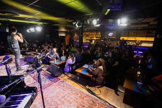 Sfeervol restaurant met live muziek aan de haven in de Zuiderzee-regio met gasten aan tafel en een kleine band