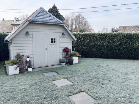 Tuin in het najaar die winterklaar wordt gemaakt met bladeren, snoeiwerk en beschermde potplanten